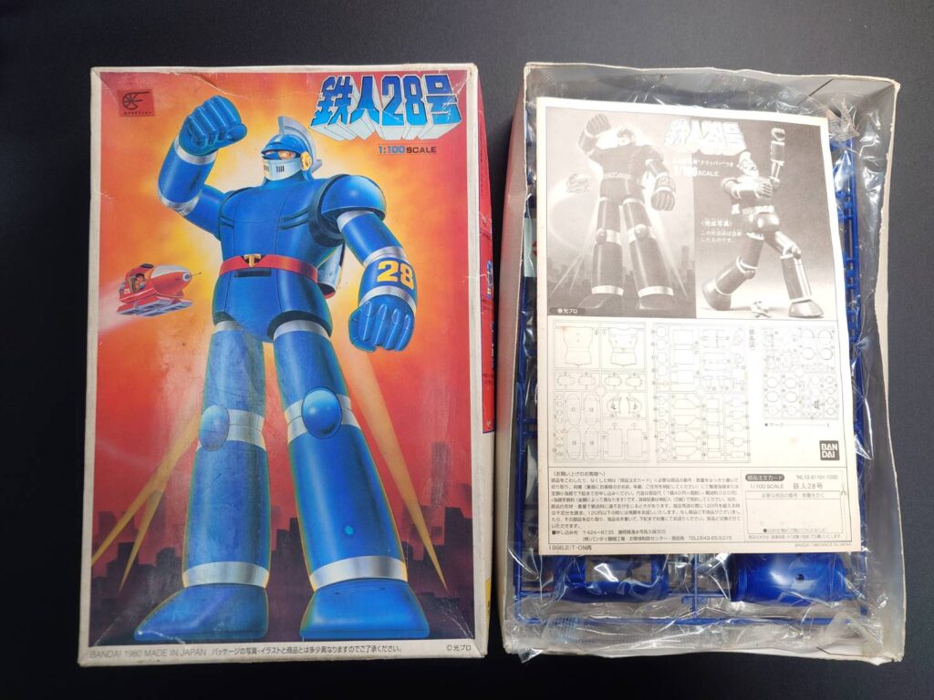 バンダイ1/100スケール鉄人28号の箱と中身を並べた写真。古いパッケージと未開封のパーツ、説明書が写っている。