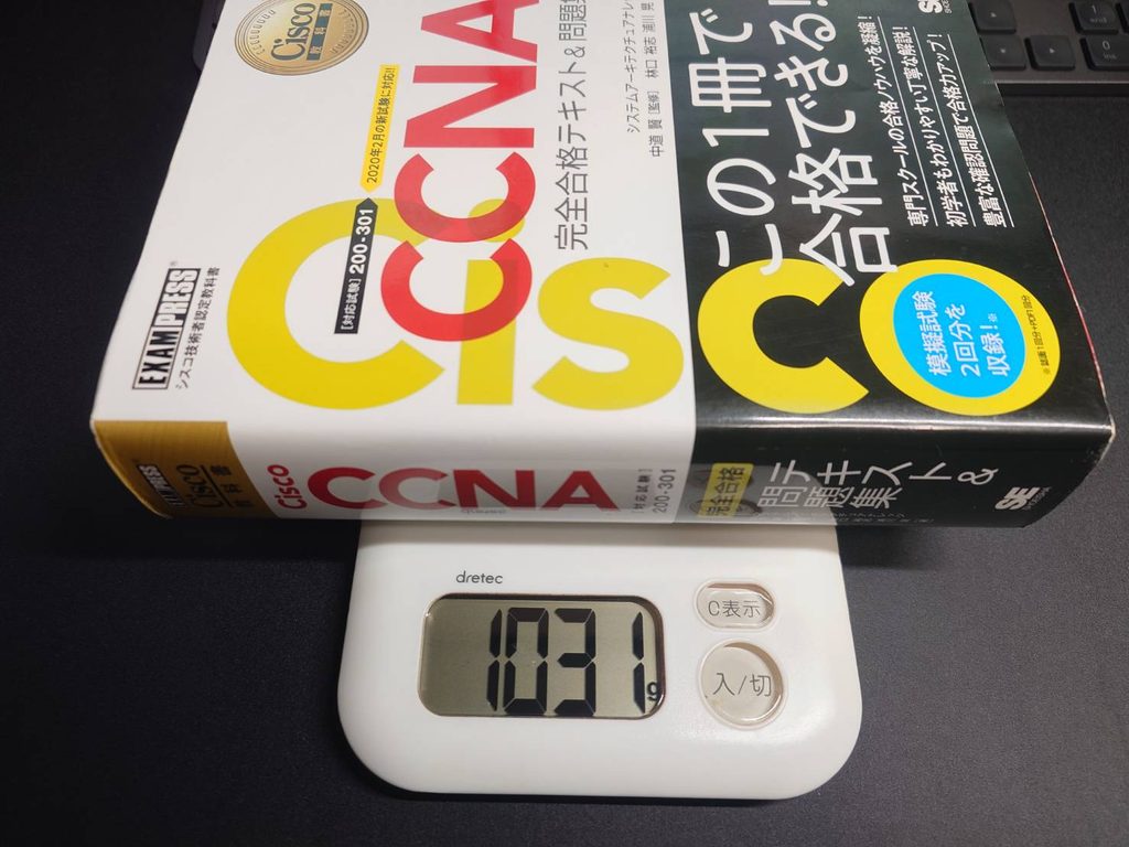 CCNA参考書をデジタルはかりで量った写真。参考書の重さが1031グラムあることを示している